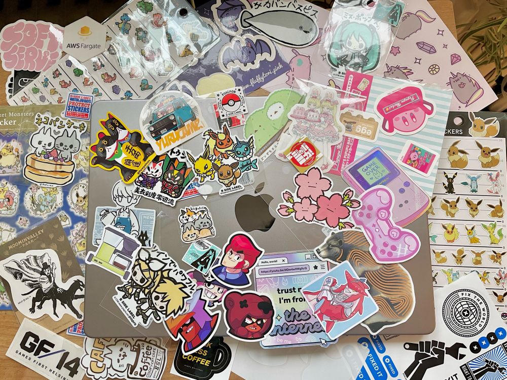 Laptop with lots of stickers around it