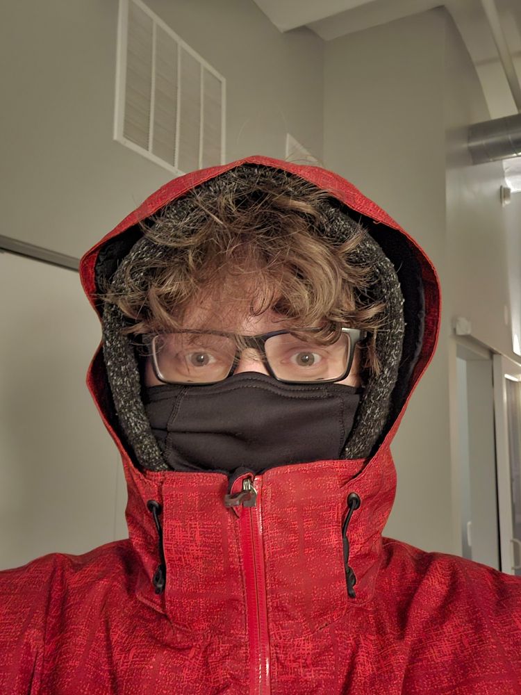 A picture of me, all bundled up wearing a ski jacket and a balaclava.