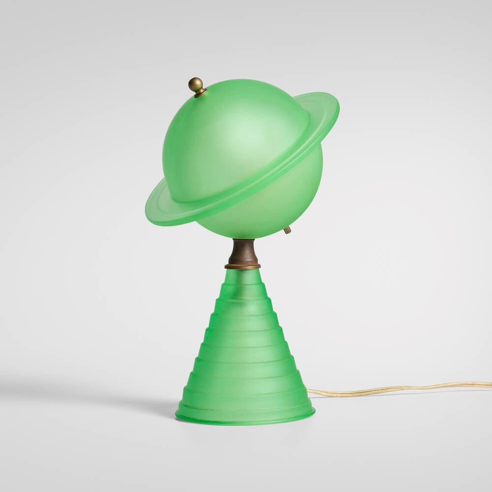 A vivid green matte glass lamp in the shape of a Saturn-like planet atop a stepped conic form