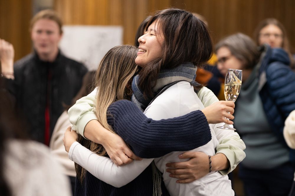 A group of students hugging and smiling.