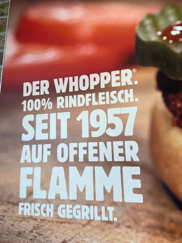 Ausschnitt aus einem Werbeplakat, auf dem steht: „Der Whopper. Rindfleisch. Seit 1957 auf offener Flamme frisch gegrillt.“