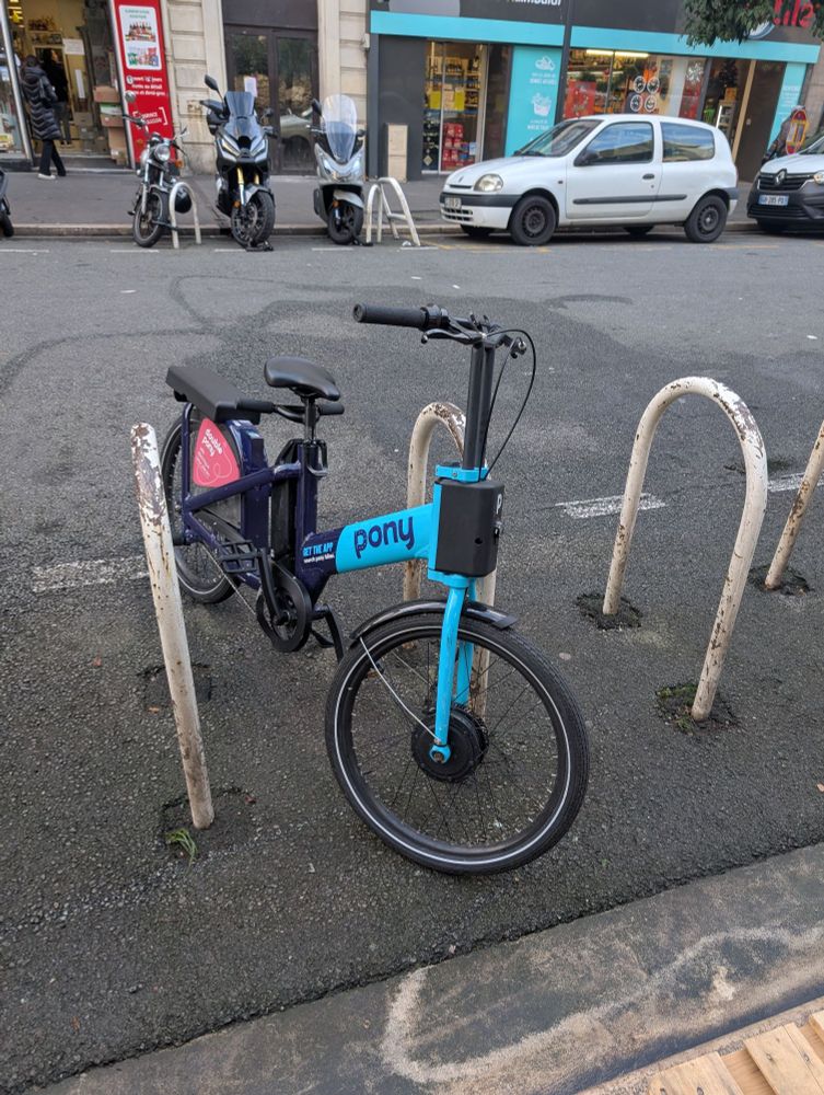 A blue and black bike that has a longer seat and handlebars behind the "standard" seat, such that the bike rider could carry a passenger on the back of the bike 