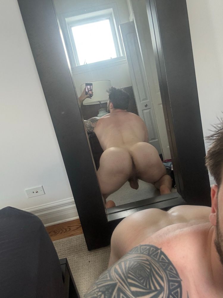 Man on all fours naked from behind, trying to take a mirror selfie of his ass 