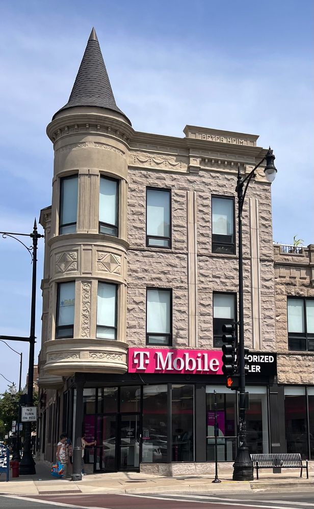 Three-story rusticated and smooth limestone building with a turret on the corner topped with a witches' hat roof. The first floor has been modified and consists of large store windows. On the second and third floors, the limestone is intact. The turret is smooth limestone decorated with foliage and geometric shapes. There are stone dentils across the roof line and the name "Peter Heim" is engraved in stone at the top left of the building. Heim was the owner and had the building constructed ca 1895. It was a saloon and bowling alley.