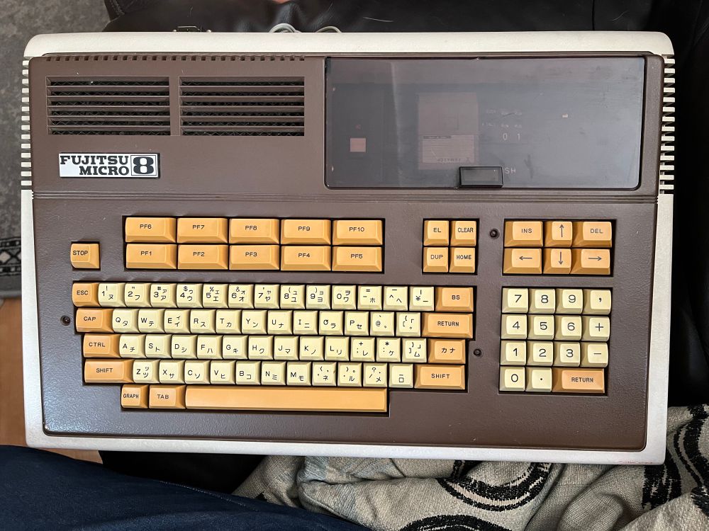A brown and white computer, it had a large covered bay on the right and the label Fujitsu Micro 8