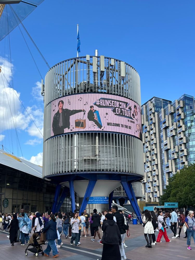 the sign for jins concert outside of the O2 arena that reads “ #RUNSEOKJIN_EP.TOUR WELCOME TO THE O2”