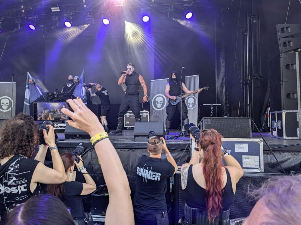 Foto auf eine Konzertbühne aus der zweiten Reihe. Auf der Bühne steht die Band Centhron.