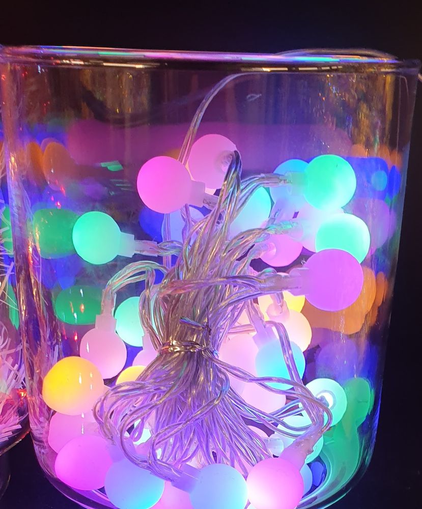 LED Kugeln klein in einem Glasbehälter.
Sie leuchten in grün, türkis  pink, gelb und blau