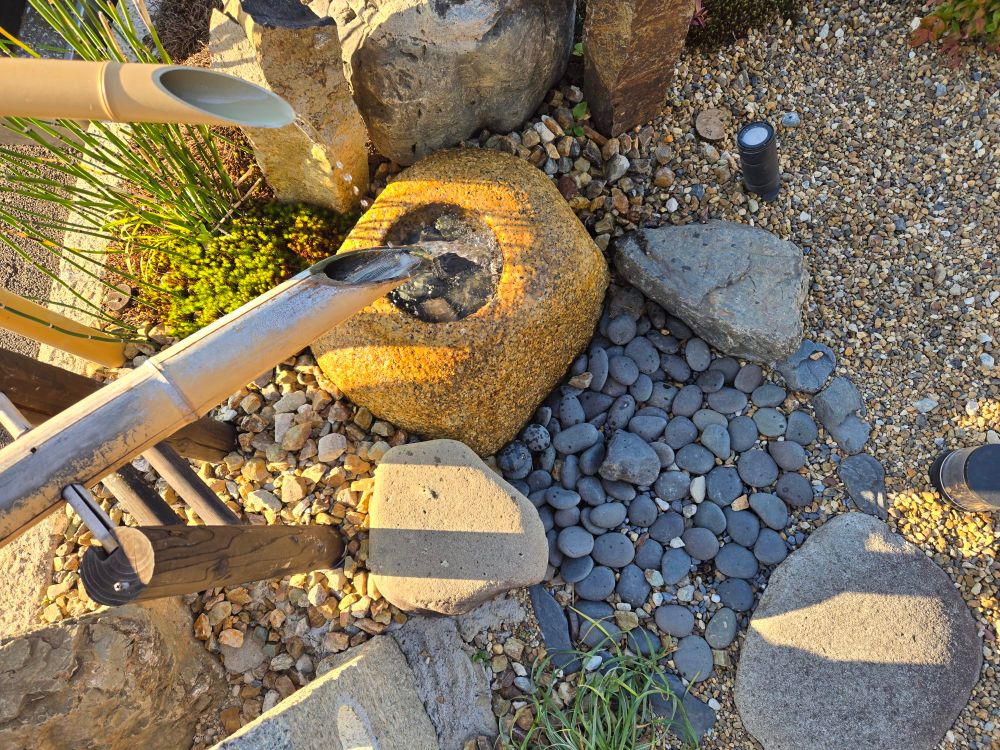 道路沿いで見掛けたミニ庭園　筧 鹿威し 蹲　パッと見 水琴窟かと思い 水がたまって落ちるまで眺めていたけど 思った音色は響きませんでした　でもちゃんと稼働させていりれるなんて珍しい　別の場所で見掛けたのは 風情良く作った人がほどなく居なくなってしまい 後をまかされた人は水を止めて放置 新しいまま朽ち掛けていましたから