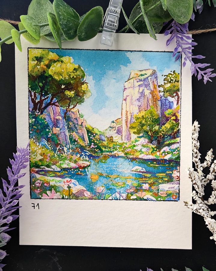 Square watercolor framed with a black line on a rectangular, portrait-oriented paper.
A crystal-clear pond reflects the towering cliffs that rise dramatically in the background. Lush greenery and vibrant wildflowers frame the water’s edge, creating a dreamy, untouched oasis. Sunlight filters through the trees, casting dappled light onto the rocky landscape. The towering rock formations add a sense of grandeur, while tiny blossoms soften the scene with delicate color. Number 71 is written in the bottom left corner.