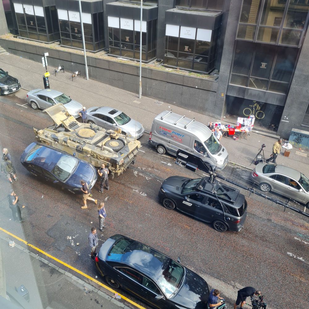 Film crew working on a tank prop with a car tilted against it on the live set in Glasgow