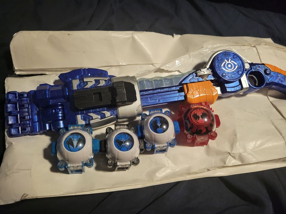 From the series Kamen Rider Ghost, various Eyecons and robotic toy gun on a white package