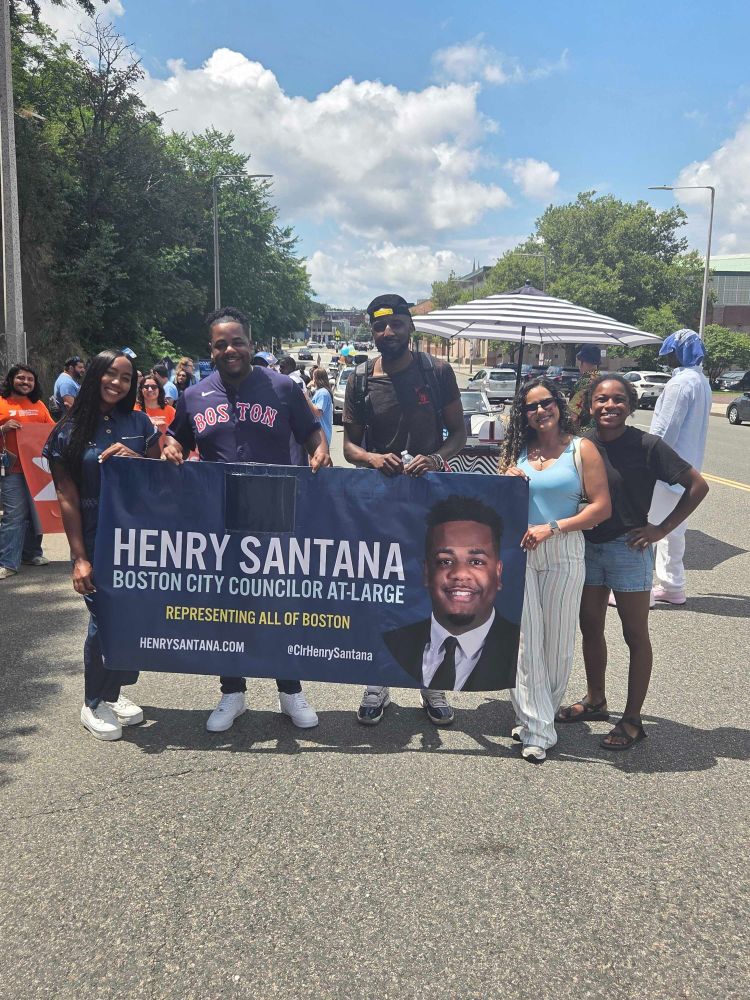 Team Santana is all smiles with the parade banner before the start of the parade