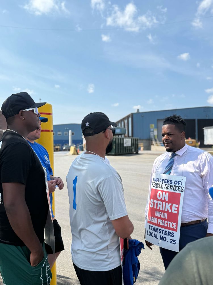 Councilor Santana listens intently to members of Teamsters Local 25 who are on strike outside Republic Services