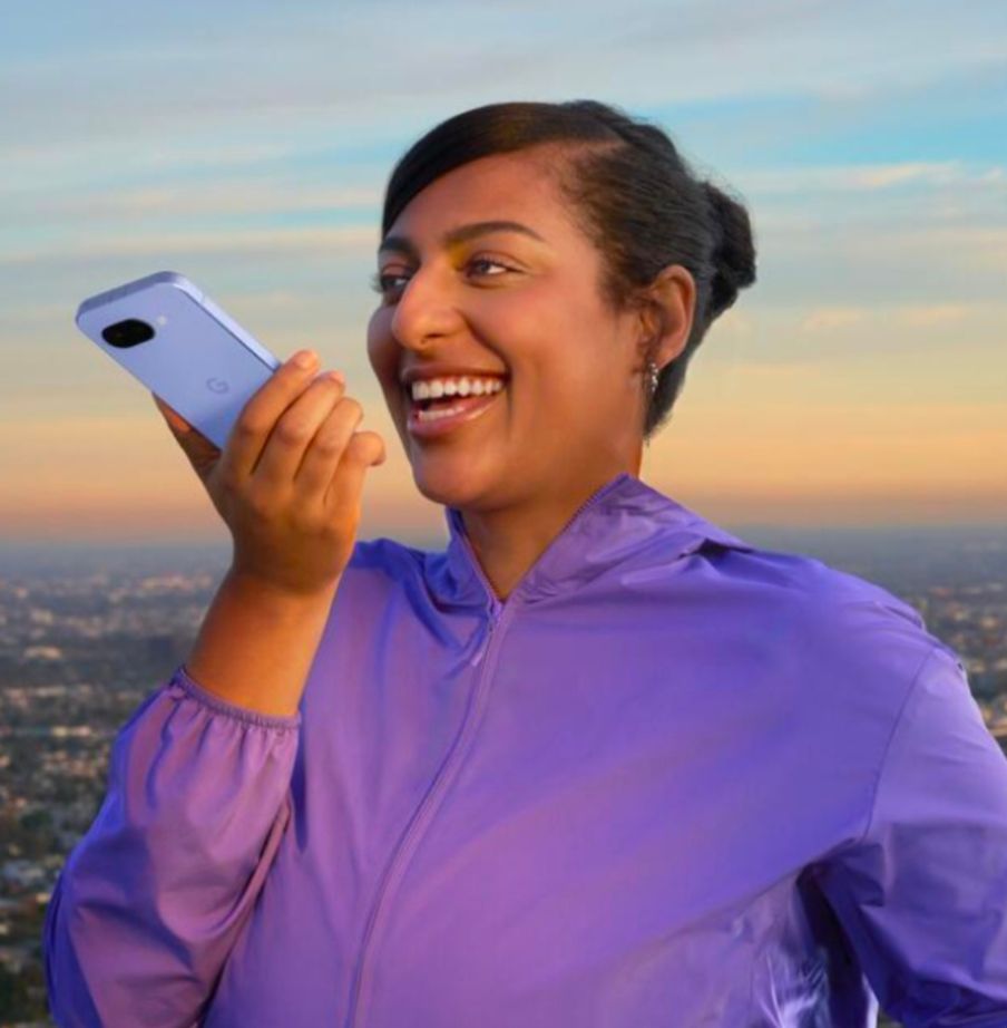 A lady holds a phone horizontal to make a phone call speaking into the charger port.