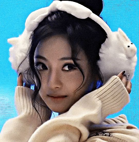 A GIF of Kpop idol Ningning from the group Aespa. She is smiling with her hands on her cheeks, looking cute. 