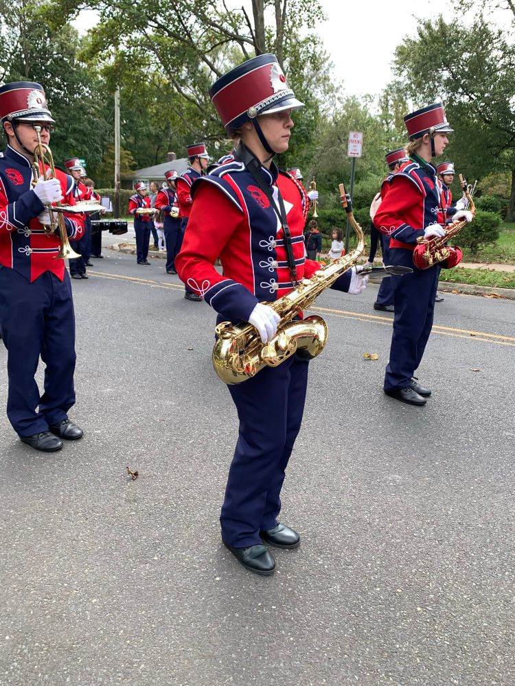 My kid in her Red and Blue high school marching band outfit with saxophone 