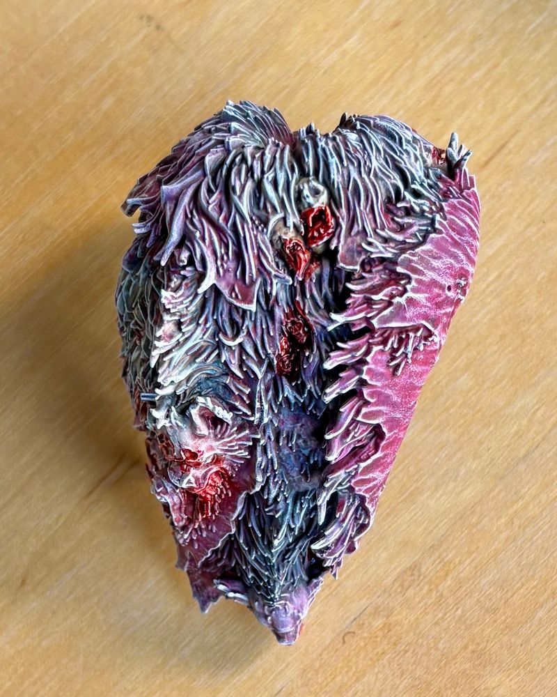 Photo of a painted component of the AoS model Ushoran. It is a cloak mantle made from rotting pelts and decorated with severed heads. Very chic.