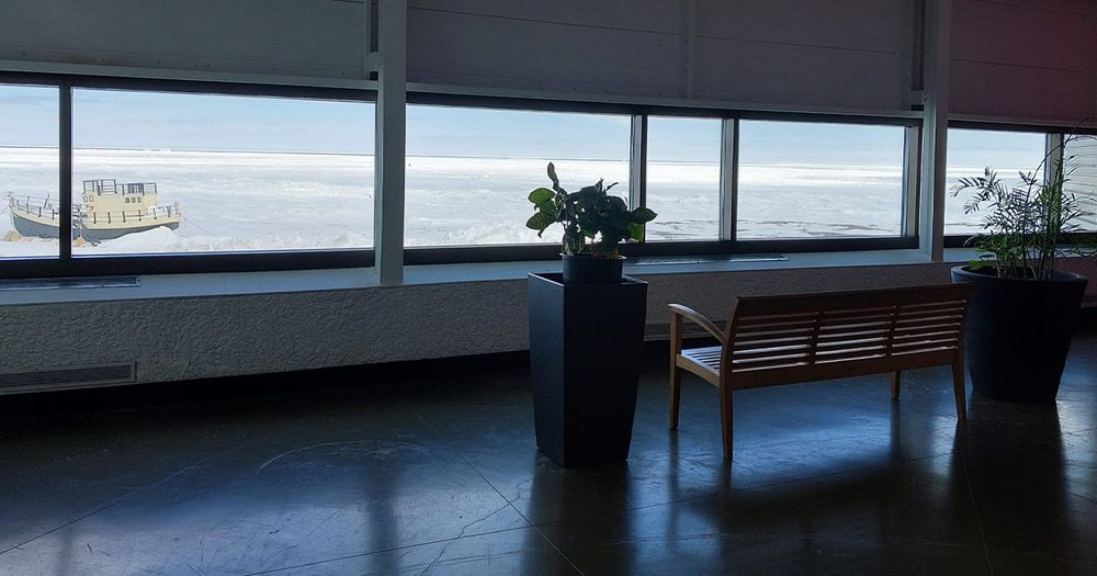 View of the frozen Hudson Bay from inside Churchill’s Town Complex, with the Beluga Boat visible through the window. Photo by Philipp Budka (2025).