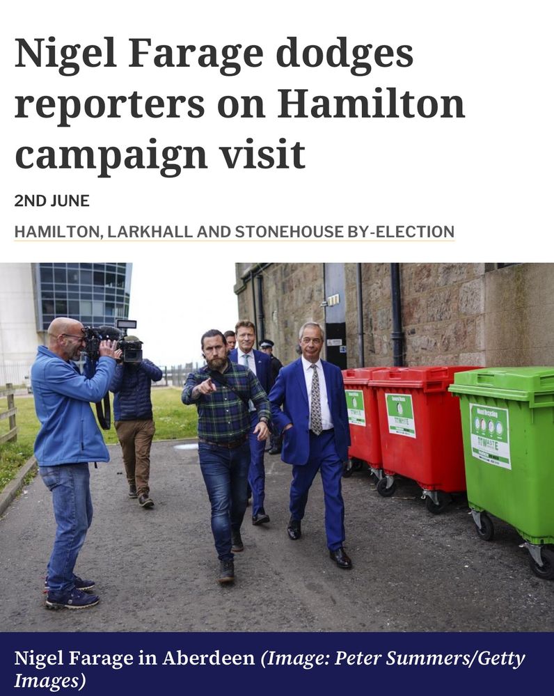 A photo of Nigel Farage walking past some industrial waste bins after hiding from reporters on a scheduled campaign visit to Hamilton in Scotland 