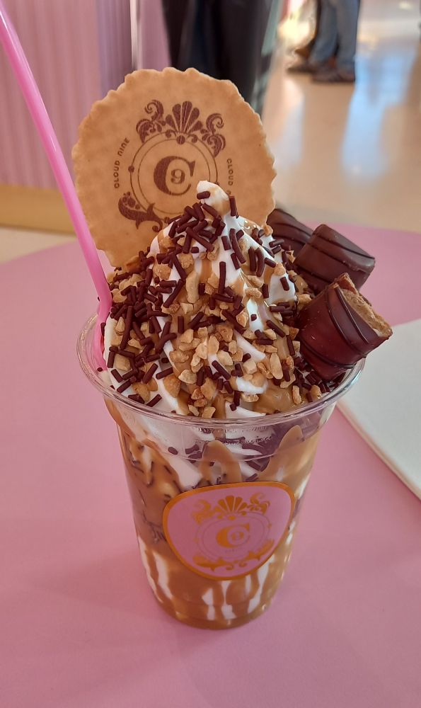 A Kinder ice cream sundae with nuts, wafer, and chocolate pieces.