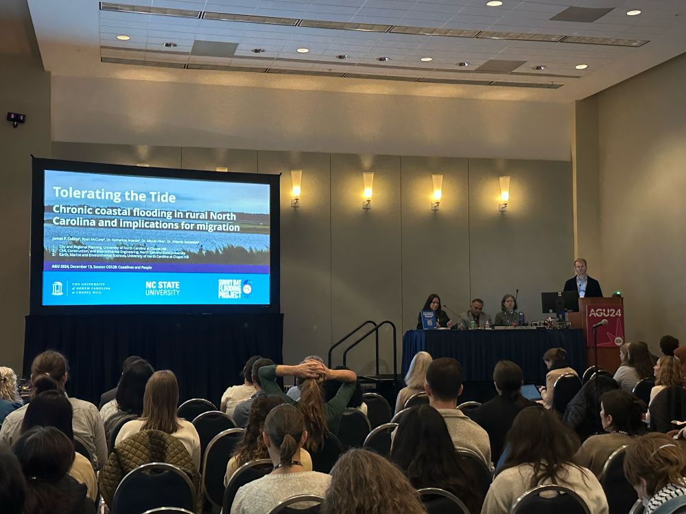 a room of scientists facing a screen with a presentation reading “Tolerating the Tide” at the AGU fall meeting