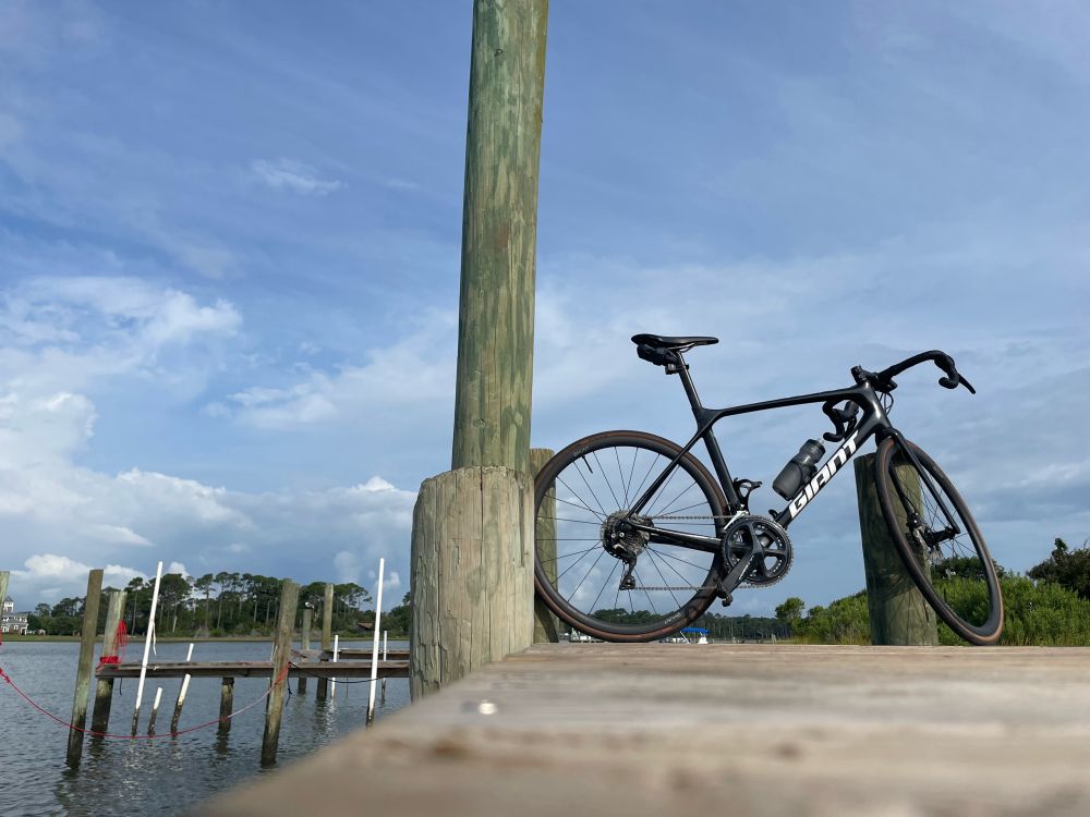 my road bike propped against a dock piling, with more docks and water in the background