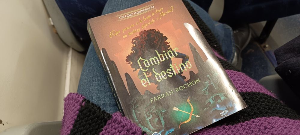 Foto del libro sobre mis piernas en el tren.