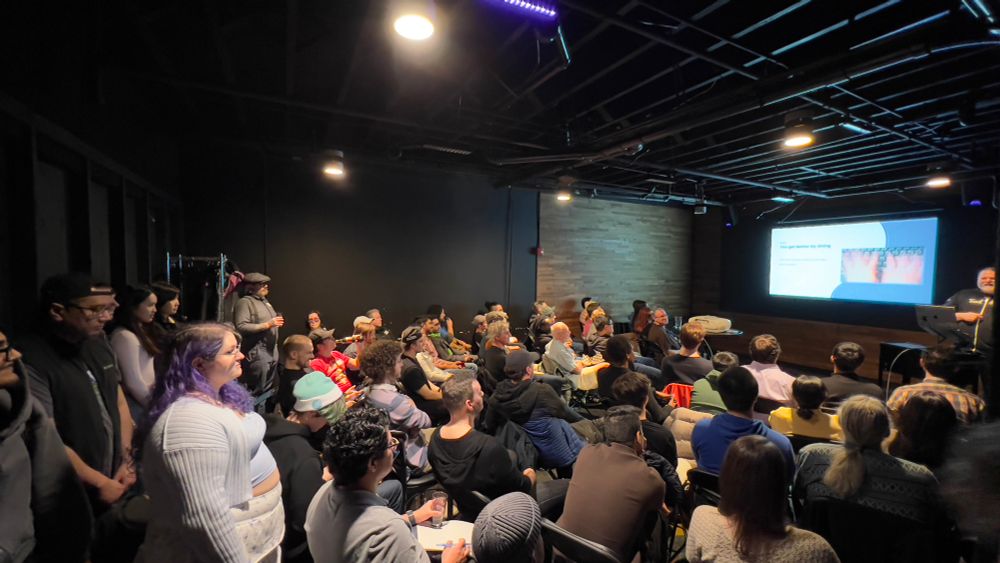 A crowd of ~60 people for a presentation. All the seats are filled and another dozen are standing in the back of the room