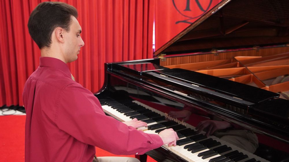 A man playing a grand piano