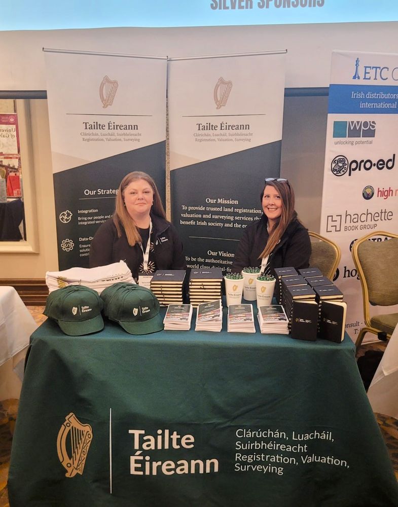 Two Tailte Éireann team members smile while set down at the organisation's stand at the IGC National Conference
