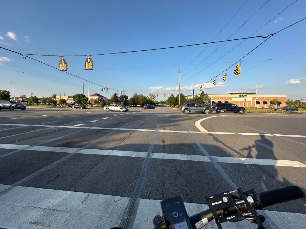 Image of a large intersection in a suburban shopping area. Taken from a bike.