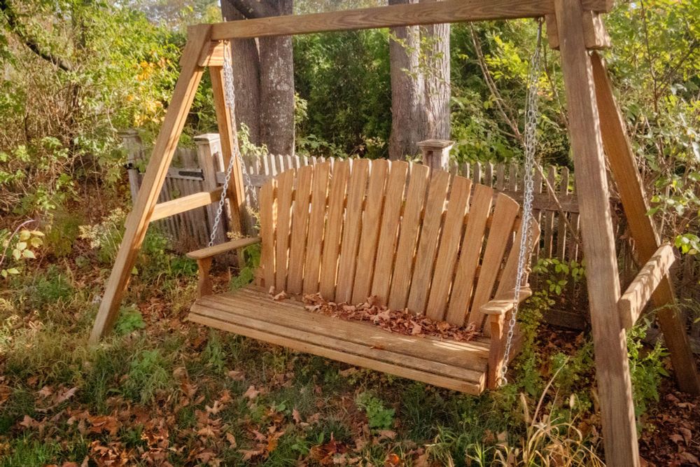A swinging bench outside in the fall