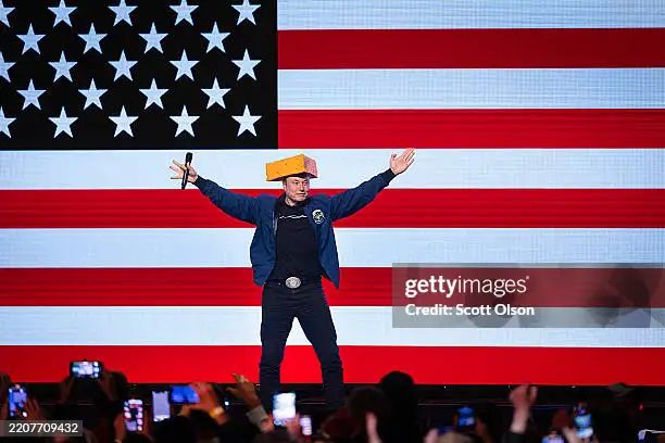 Elon Musk wearing a cheesehead like a doofus