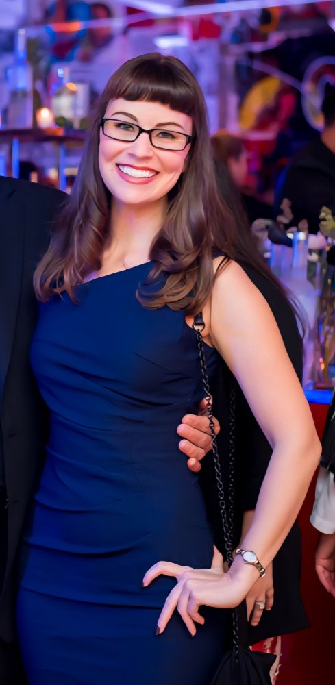 Rebecca in a navy blue dress, smiling.