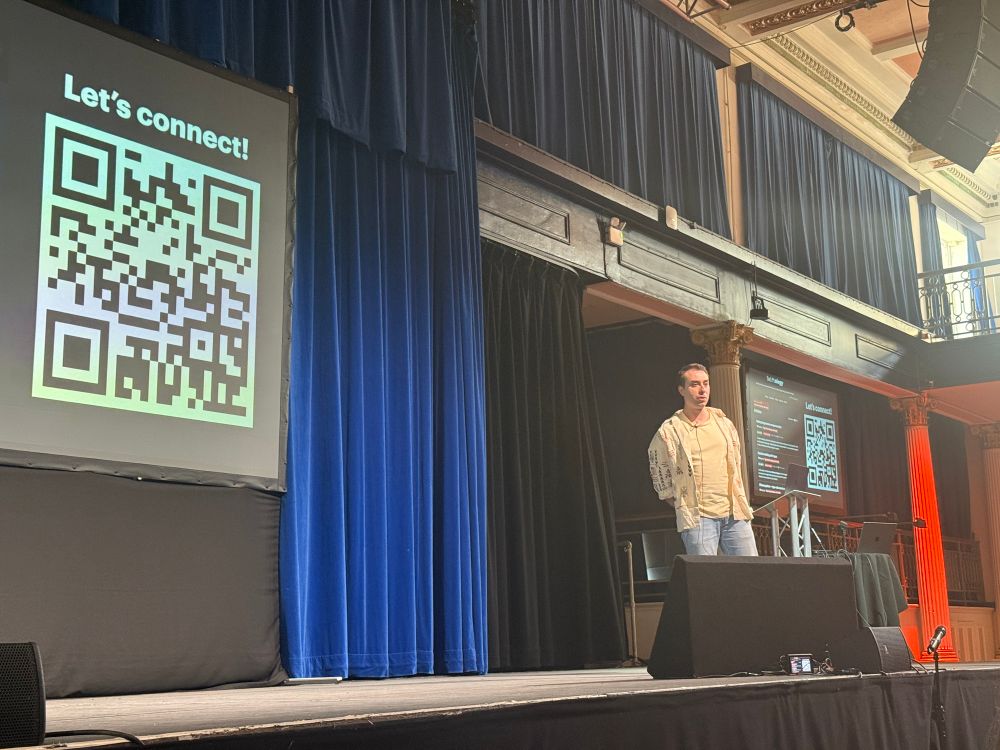 Alex presenting a slide with a QR code on labeled “let’s connect!”