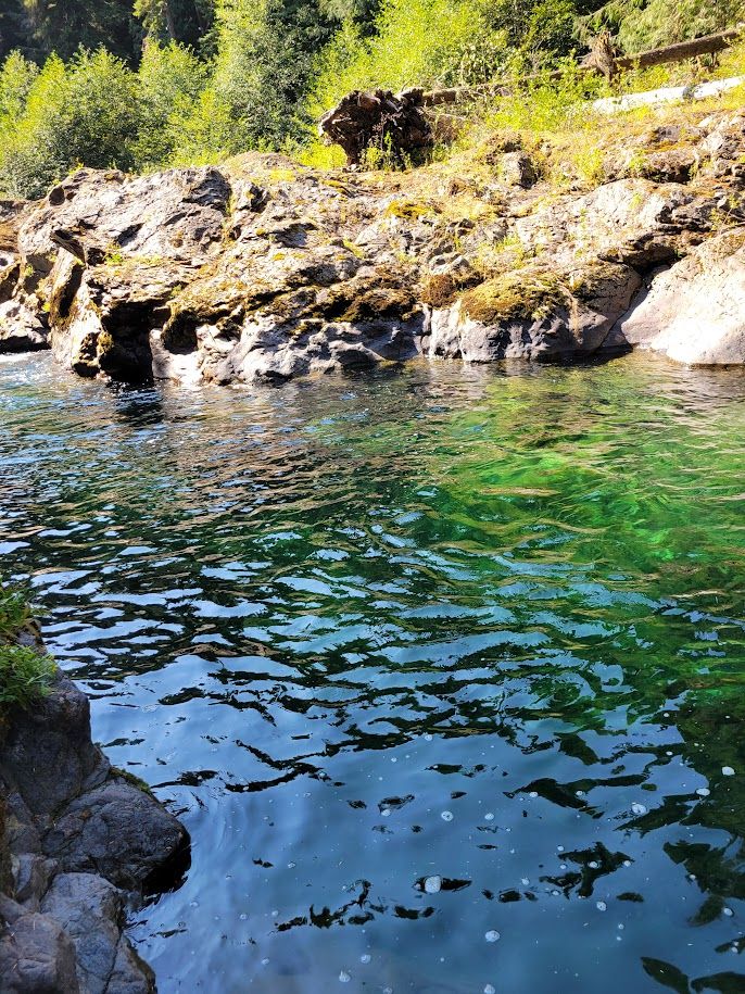a river of green blue water with ripples
