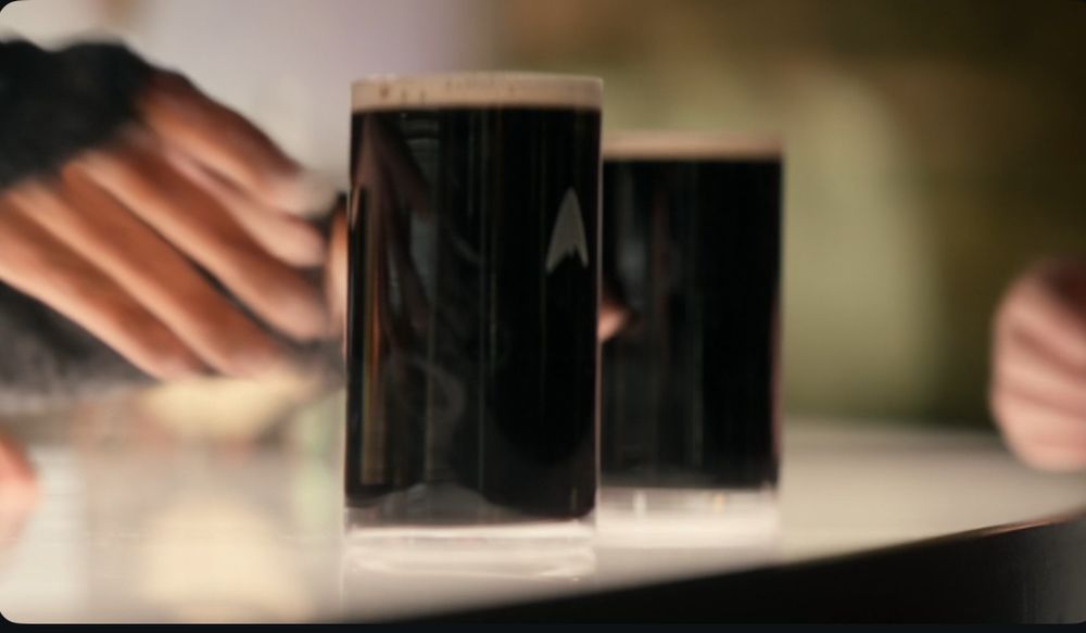 Two very shitty pints of Guinness in a federation branded glass, taken from Strange New Worlds