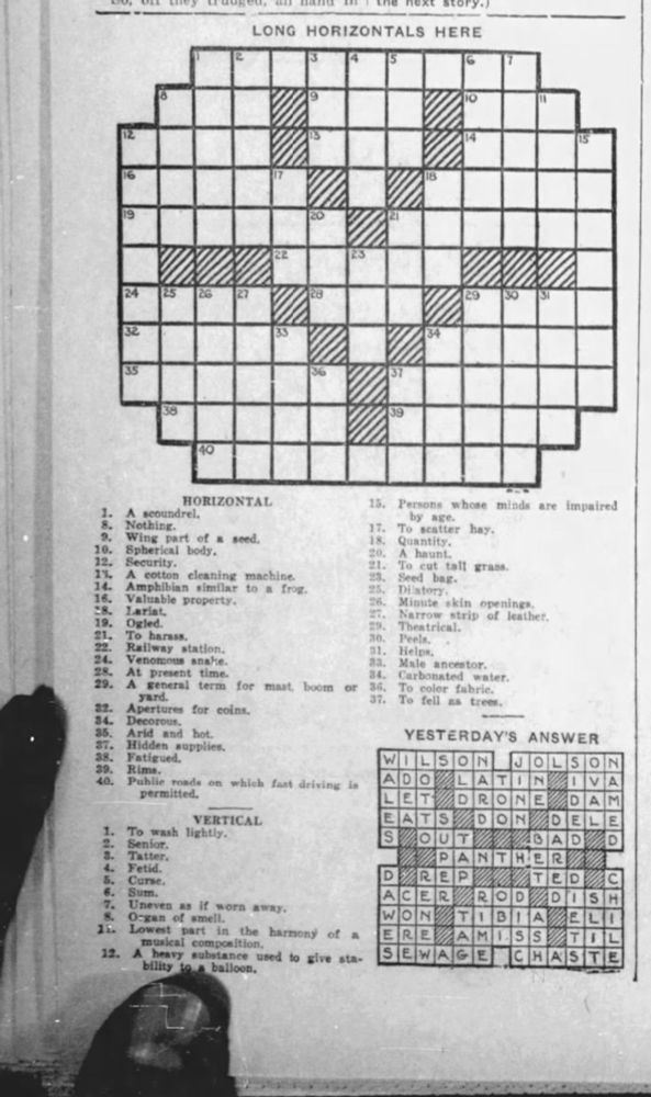 Microfilm of a newspaper crossword puzzle from 1929 with fingers in the picture.