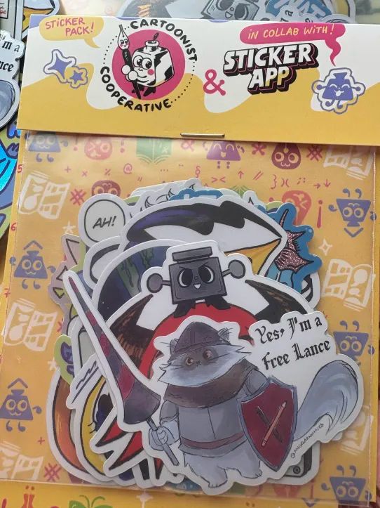 A colourful pack of die cut stickers, designed by 12 different artists. The label shows the Cartoonist Co-op logo with the StickerApp logo with a doodle of Inkling saying "In collab with!"