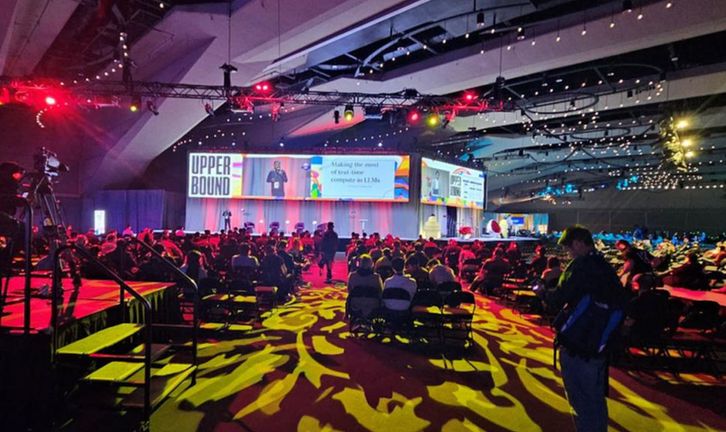 Conference audience and stage with coloured lighting.