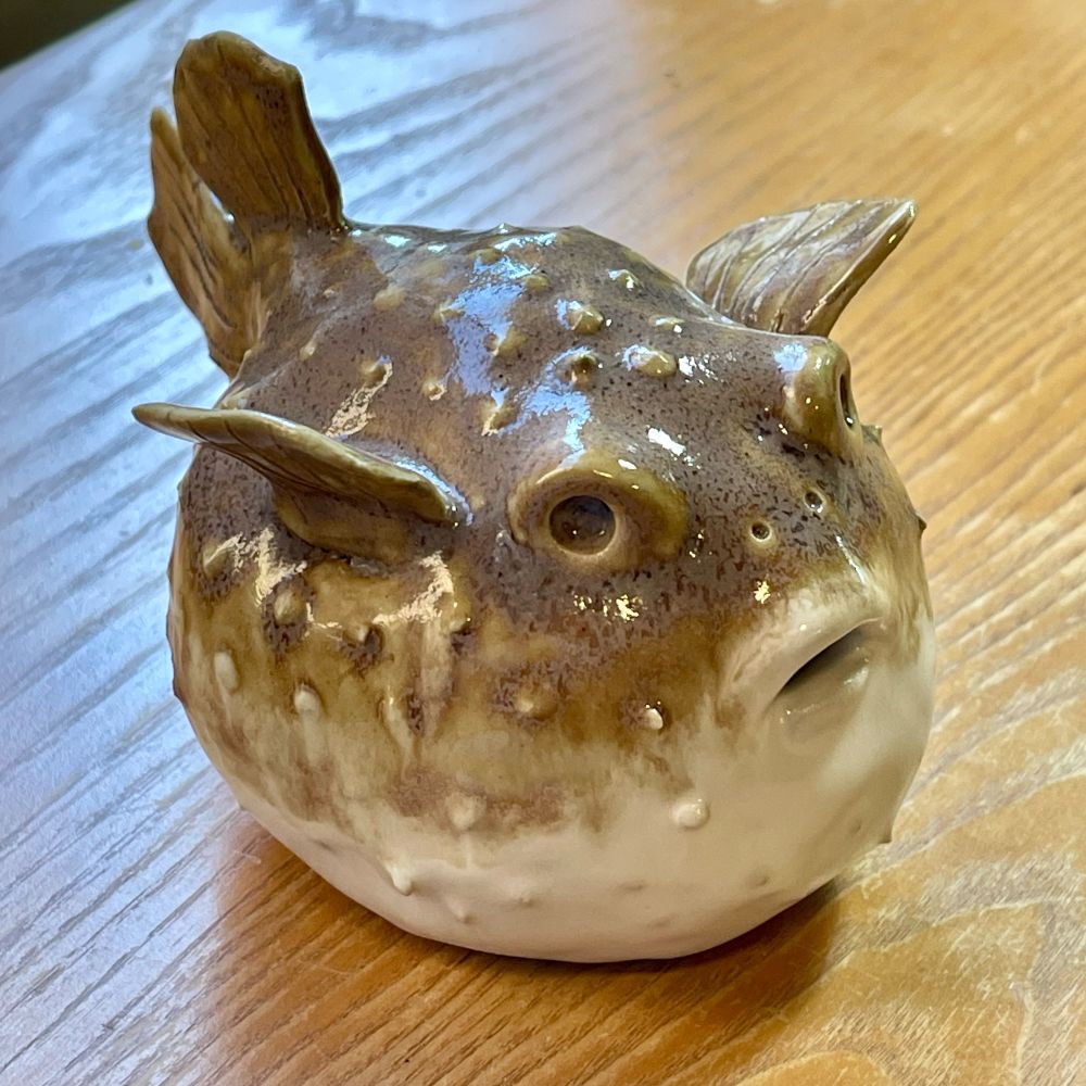 A small ceramic sculpture of a puffer fish