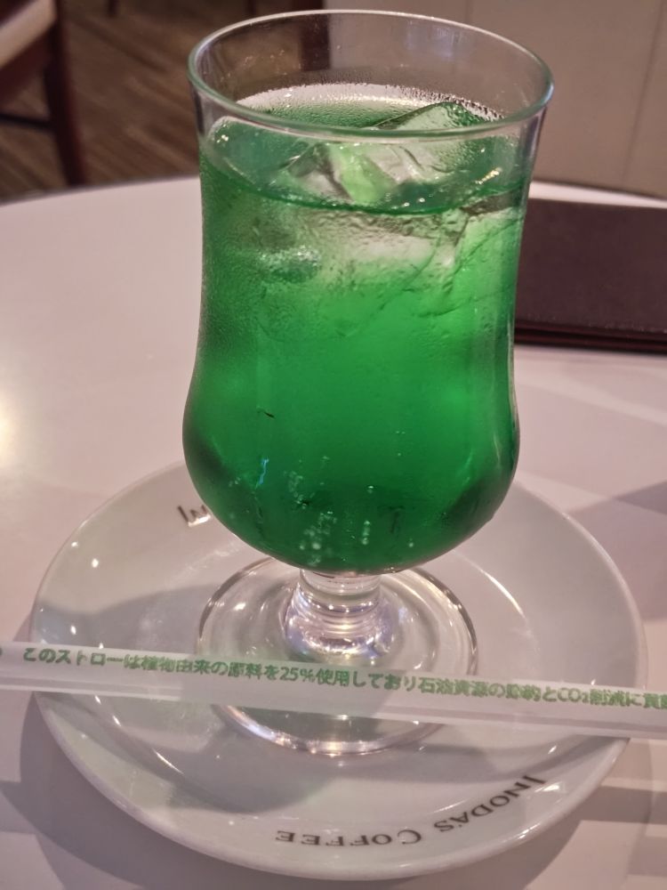 イノダコーヒー本店のメロンソーダ　下の方が少し膨らんだグラスに緑の涼し気なソーダが注がれている