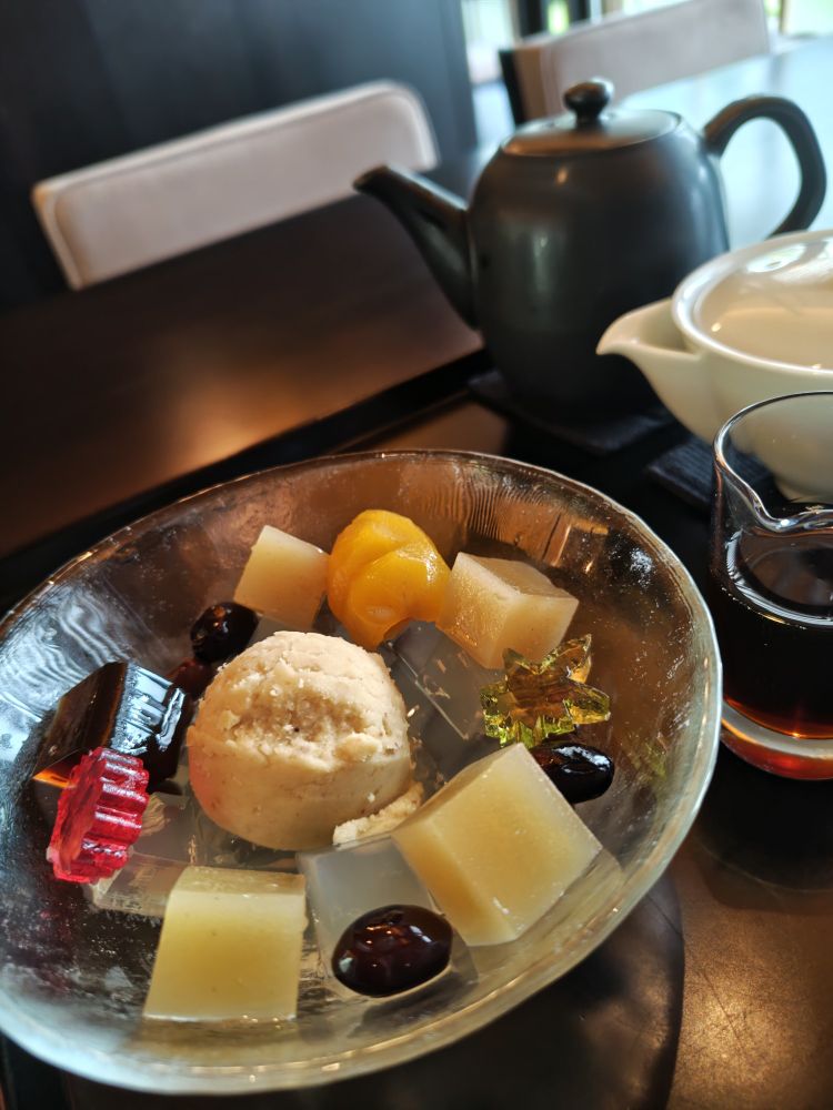 虎屋菓寮の栗あんみつ。ガラスの器に盛り付けられています。セットのお茶は温かい煎茶。お湯と急須と茶碗がお盆に載せられており自分で注ぐスタイルです。