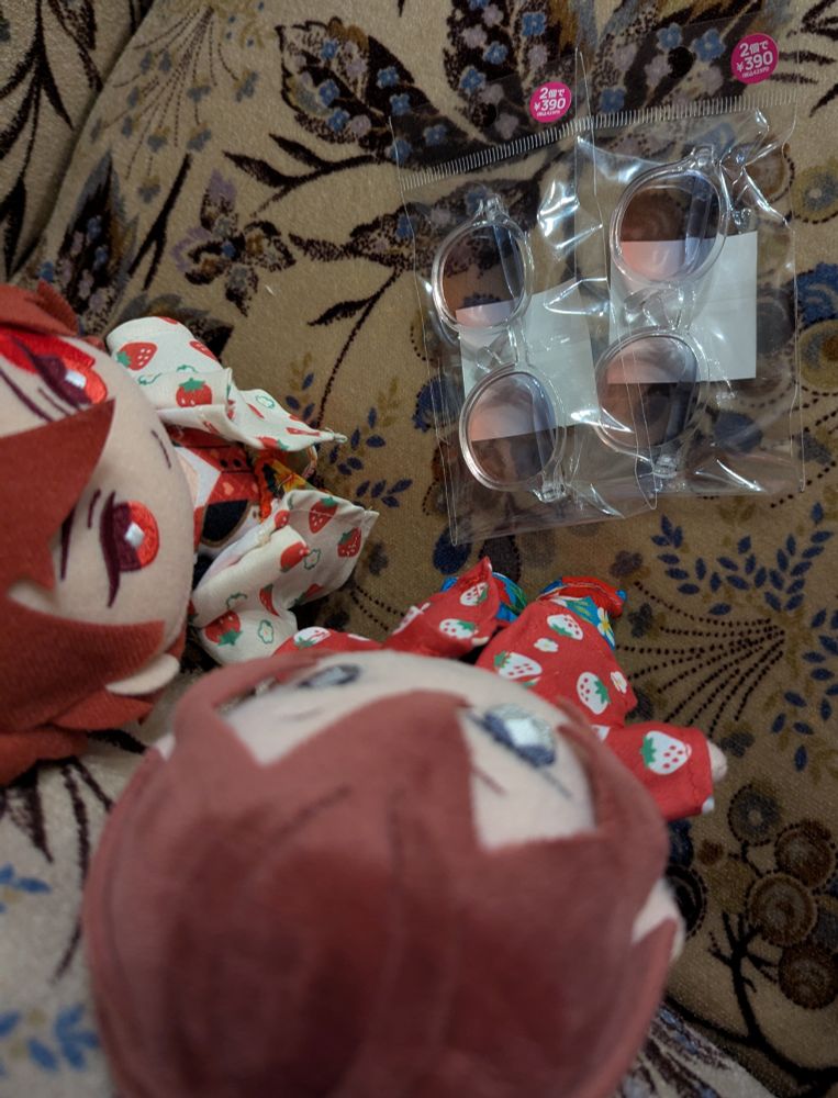 390マートで2個税別390円だったぬいぐるみ用のカラーサングラスを見つめている　アロハシャツを着たリドル·ローズハートとエース·トラッポラのぬいぐるみ
カラーサングラスは上から下にかけて青からピンクヘなっていくグラデーションカラ一になっている