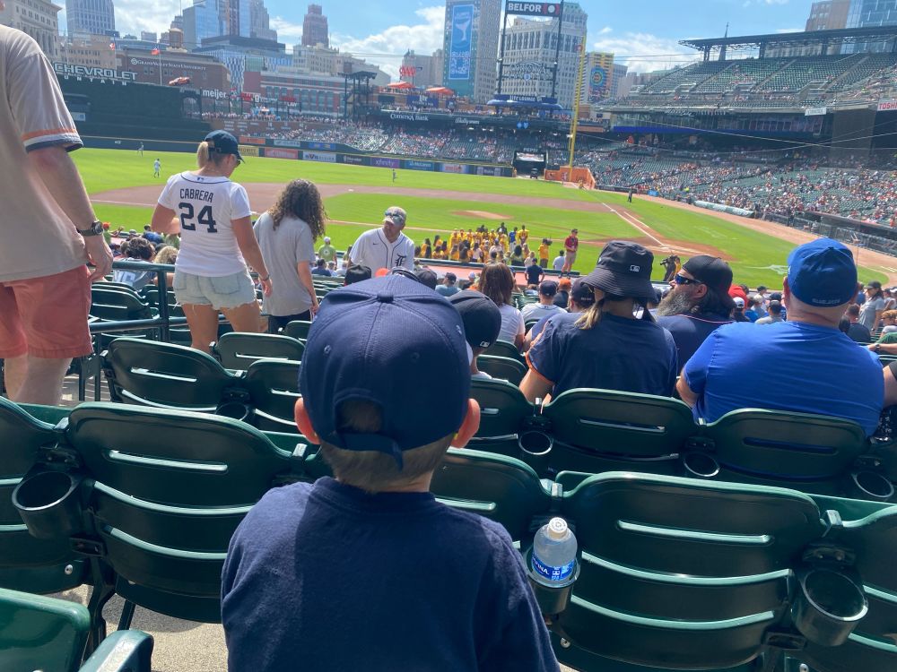 View of inside Comerica Park with the back of a kid looking at the park