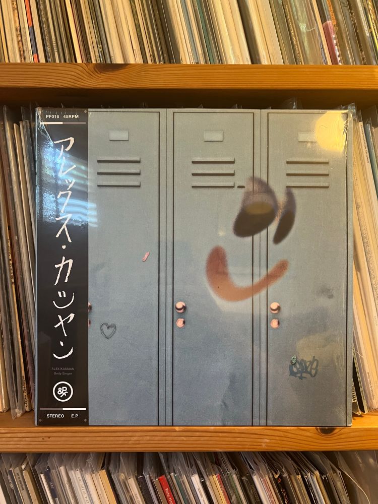 A vinyl record cover showing school lockers with a smiley graffiti face drawn on them 