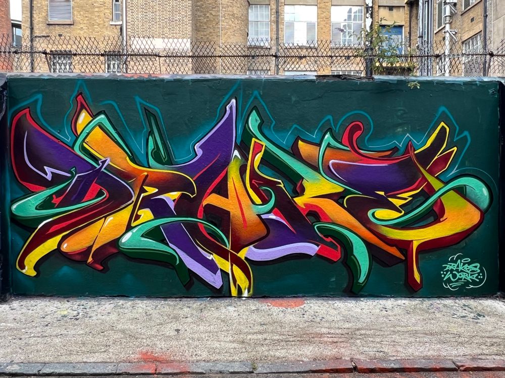 Yellow purple green wildstyle graffiti on a street hoarding 