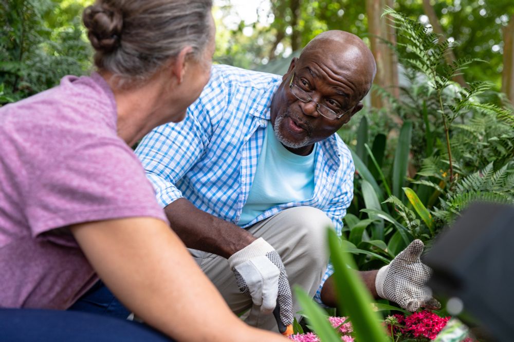 two older adults gardening together and smiling