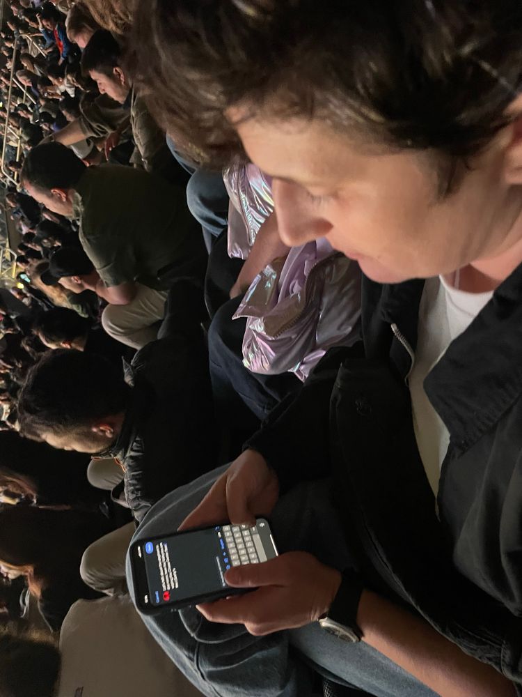 Tessa typing out this tweet at the Valkyries game